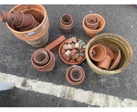 A quantity of terracotta plant pots and other items 