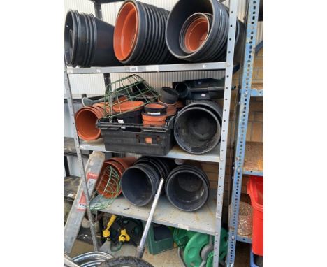 A large quantity of plastic flower pots and a shelf of hose reels and accessories 