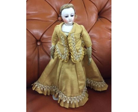 Antique 10" bisque head and shoulders doll with leather body. On stand.