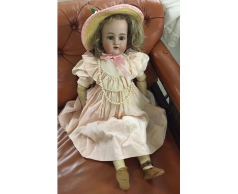 27" antique bisque head doll by Simon & Halbig. Jointed composition body, later hair wig. Dressed for display.