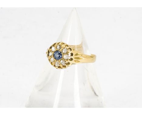 An Edwardian 18ct gold sapphire and diamond cluster ring, the circular Ceylon sapphire surrounded by rough cut diamonds, all 