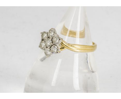 An 18ct gold diamond flower head dress ring, the seven modern brilliant cuts in white gold claw settings, each approximately 