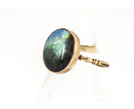 A black opal gold ring, the Georgian style setting with cushion worked back on an ornate yellow metal shank, supporting an ov