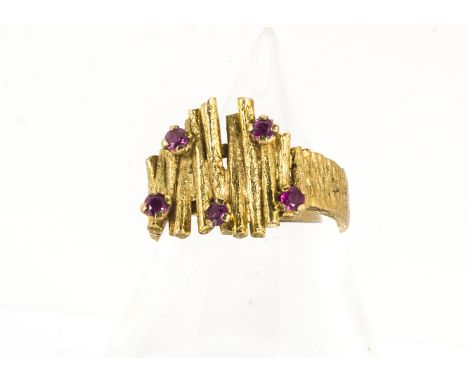 A 1970s ruby and textured 9ct gold dress ring, the five claw set rubies in a linear design setting, ring size N, 5g 