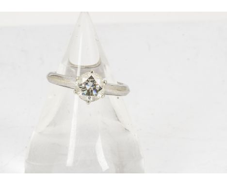 A diamond solitaire, the brilliant cut in a six claw setting on a plain crown gallery and white metal shank, marked to interi
