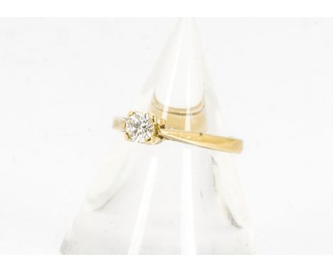 An 18ct gold diamond solitaire, the brilliant cut in four claw setting on a yellow gold mount and shank, marked 750, and Mill