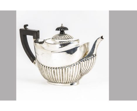 A late Victorian silver teapot, helmet shaped with fluted lower, 11.4 ozt, with applied black handle and finial 