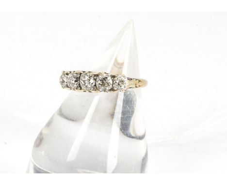 A five stone diamond ring, the old cut diamonds in claw setting with scroll gallery on an 18ct marked yellow metal shank, 3.7