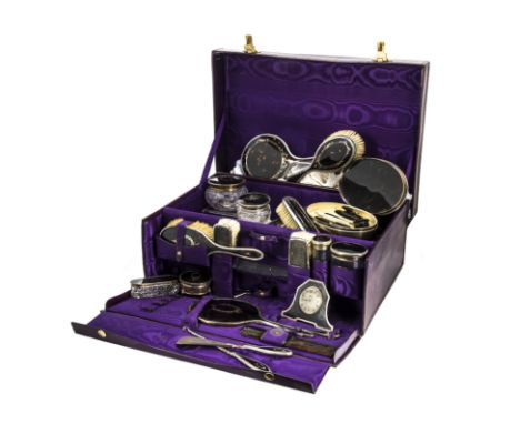 A 1920s silver and tortoiseshell vanity travel set, presented in a purple leather case with fitted compartment, marked J McJ,