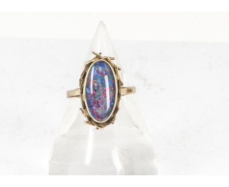 A 9ct gold black opal doublet dress ring, the oval cabochon in a textured setting on  a plain gold shank marked 9ct, ring siz