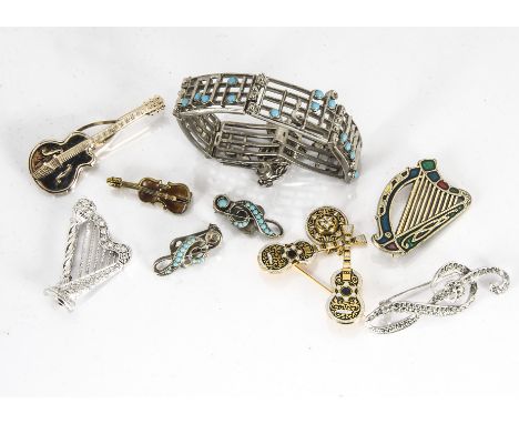 A collection of musical themed costume jewellery, including a base metal and enamel violin, a Spanish guitar brooch, pair of 