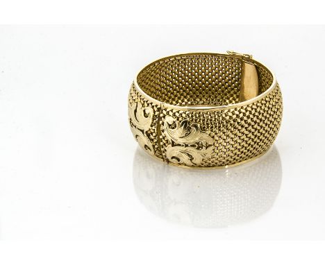 A continental 750 marked yellow gold bangle, the basket design with applied scroll design, tongue and box clasp marked with s