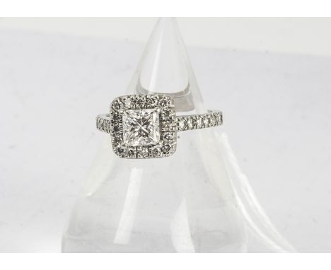 A certified diamond engagement ring, the princess cut central diamond surrounded by a bezel of brilliant cuts on diamond set 