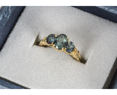 An alexandrite 18ct gold three stone dress ring, the mixed oval cuts in claw setting on a gold shank, alexandrite weight 2.17