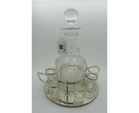 A Circular Plated Twin Handled Spirit Decanter Stand, fitted to the centre with a glass stoppered decanter and set of six cle