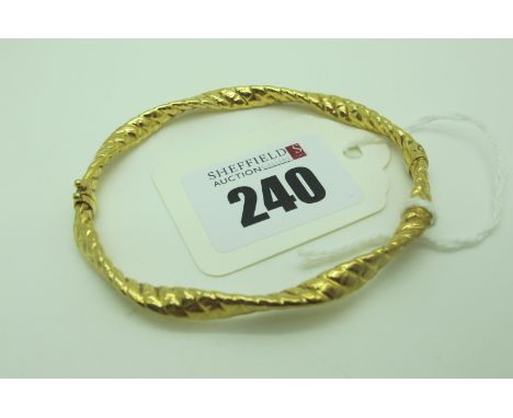 A Modern Hinged Bangle, of twisted textured design, (sprung hinge) stamped "9kt" (overall weight 6grams).  