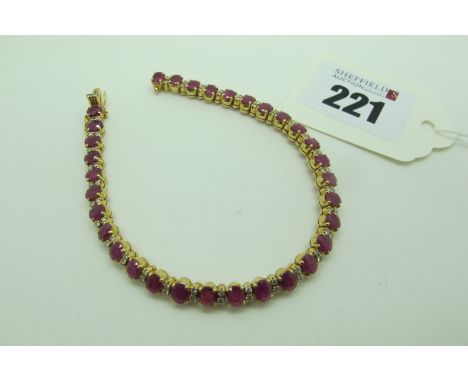 A Modern Ruby and Diamond Line Bracelet, oval claw set throughout wit uniform stones, with brilliant cut diamond set highligh