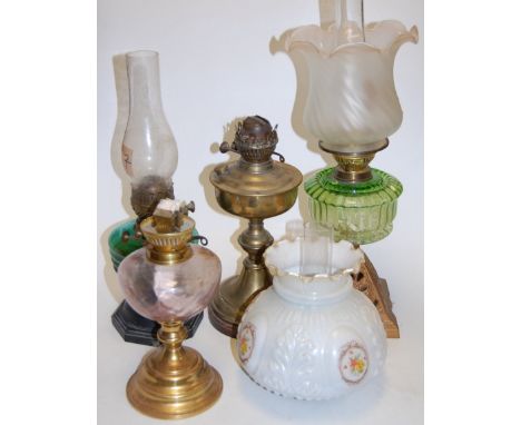 A Victorian oil lamp, having frilled glass shade above a green glass reservoir, on pierced iron base, h.50cm; together with t