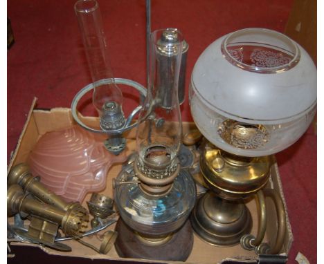 An early 20th century brass pedestal oil lamp having etched globular glass shade together with two other oil lamps, 1950s cei