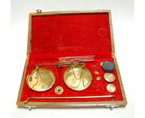 A cased set of brass scales and weights
