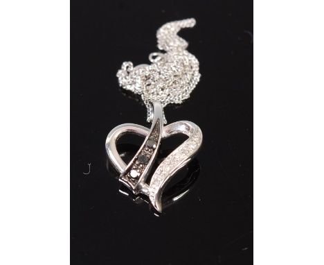 A modern 9ct white gold black and white diamond point set heart shaped pendant on finelink neck chain