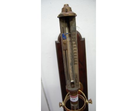 A brass cased marine stick barometer, having silvered dial with millibars, on gimble support and mahogany backing (a/f), leng