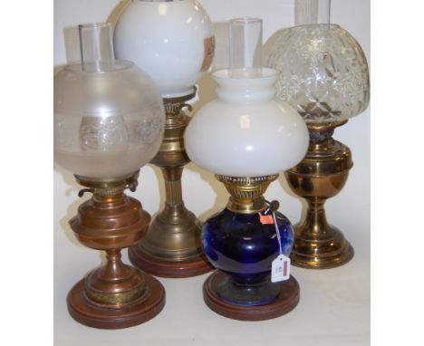 A circa 1900 oil lamp with opalescent glass shade, having blue transfer decorated porcelain body on wooden plinth, h.46cm; to