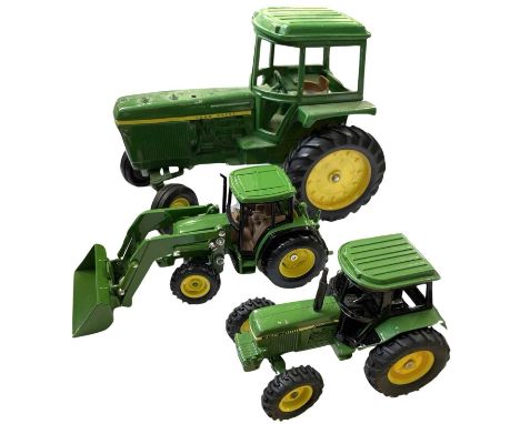Two die-cast John Deere tractor models, plus one other.