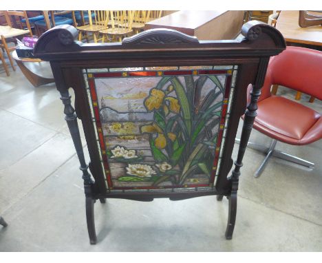 A late 19th/ early 20th century carved oak and stained glass firescreen 
