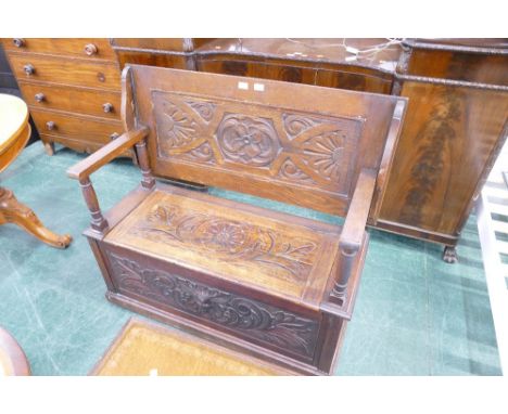 20th century Victorian inspired monks bench with carved top and seat with lift up section, the front panel carved in the Gree