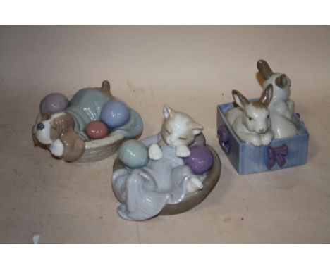 THREE NAO FIGURES OF RABBITS, A CAT AND A DOG IN BASKETS 