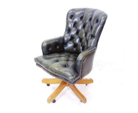 An early 20th century green leather upholstered swivel desk chair 