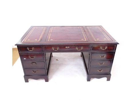 A reproduction mahogany veneered twin-pedestal writing desk, with a a 3-section red leather tooled top and fitted drawers, W1