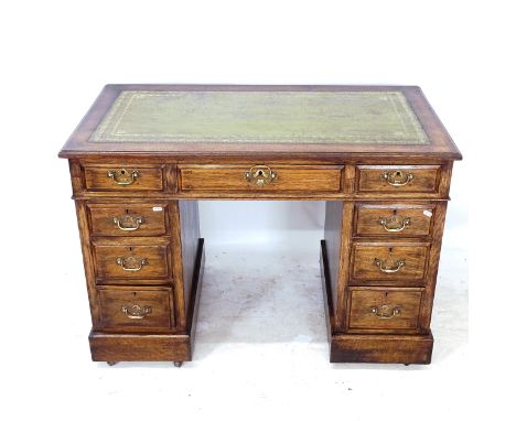 A Victorian oak pedestal writing desk, with tooled and embossed green leather skiver, and 9 drawers, W107cm, H74cm, D60cm, kn