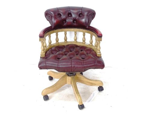 A burgundy leather button-back upholstered swivel desk chair 