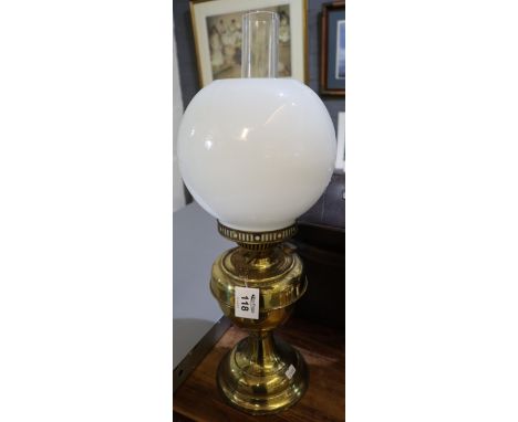 Brass double burner oil lamp with brass reservoir and pedestal base, white glass shade and clear chimney.(B.P. 24% incl. VAT)
