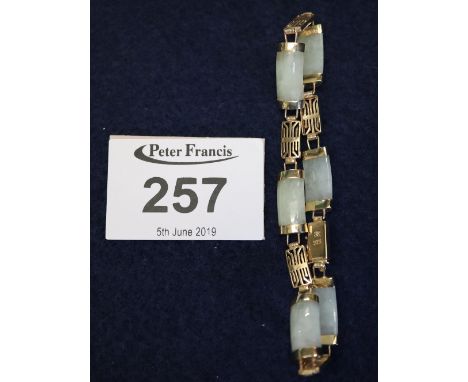 A 9ct gold and jade bracelet. (B.P. 24% incl. VAT) 