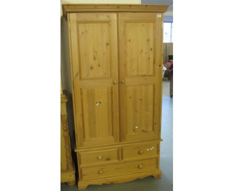 Modern pine two door wardrobe with an arrangement of drawers and on bracket feet.(B.P. 24% incl. VAT)