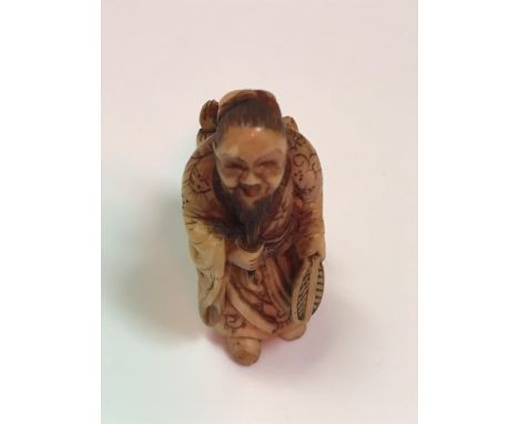 A Japanese Meiji Period netsuke as a bearded man, a child on his back , signed to base (child's left hand damaged), 3.5cm hig
