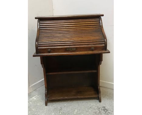 An early 20th Century oak student's desk, the plain top over a tambour front enclosing a basic fitted interior with pigeon ho