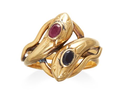 A RUBY AND SAPPHIRE SNAKE RING in high carat yellow gold, designed as two entwined snakes jewelled with an oval cut ruby and 