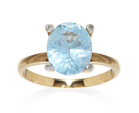 A TOPAZ AND DIAMOND DRESS RING in 9ct yellow gold, set with an oval blue topaz of approximately 4.01 carats, with four round 