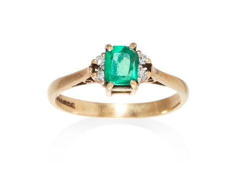 AN EMERALD AND DIAMOND RING in yellow gold, set with an emerald cut emerald between round cut diamonds, British hallmarks, si