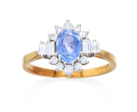 A SAPPHIRE AND DIAMOND CLUSTER RING in 18ct yellow gold, set with a central oval cut sapphire of approximately 1.04 carats in