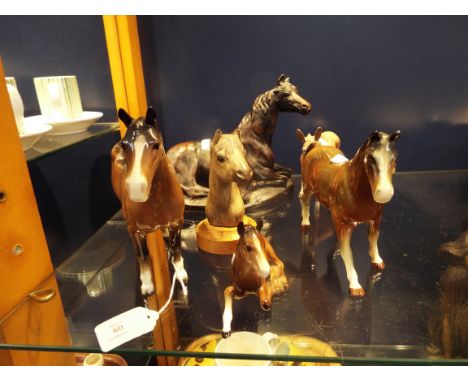A Beswick stallion, mare and foal together with a Poole pottery mounted horses head, a resin seated horse and a Bracken Earl 