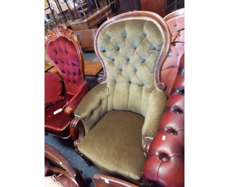 A Victorian walnut framed spoon and button back armchair with scrolling arm and serpentine seat raised on turned supports 