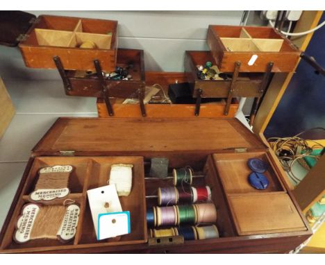 A vintage wooden workbox containing sewing accessories and another