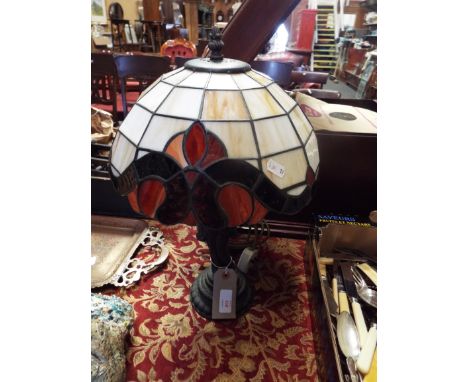 A Tiffany style lamp of female form with glass shade