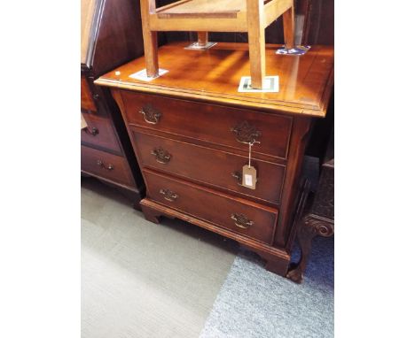 A Georgian style yew wood cross-banded chest of three cock-beaded drawers each with brass architectural swan neck handles and