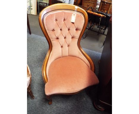 A Victorian style button back nursing chair with serpentine seat raised on squat cabriole supports